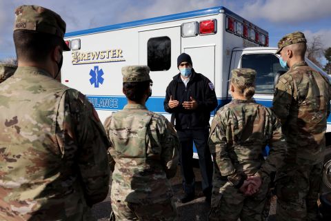 Paramedic Dan Harris, center, walks National Guard members through the ins and outs of the ambulances that they will be driving in Brockton, Massachusetts, on December 28. Guard members received clinical support and Covid-19 training from Brewster Ambulance.