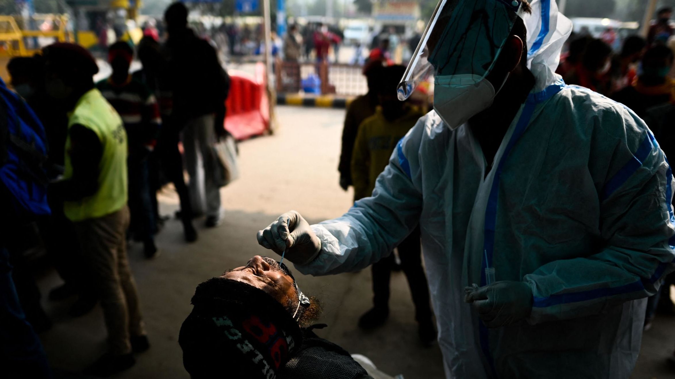 A health worker performs a Covid-19 screening at a railway station in New Delhi on January 1, 2022. 