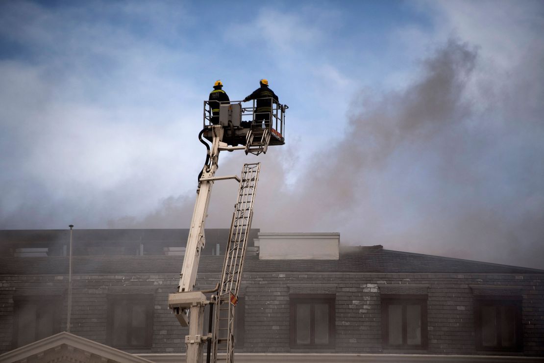 A raised firefighting platform is moved close to the roof of the National Assembly building in the parliamentary complex.