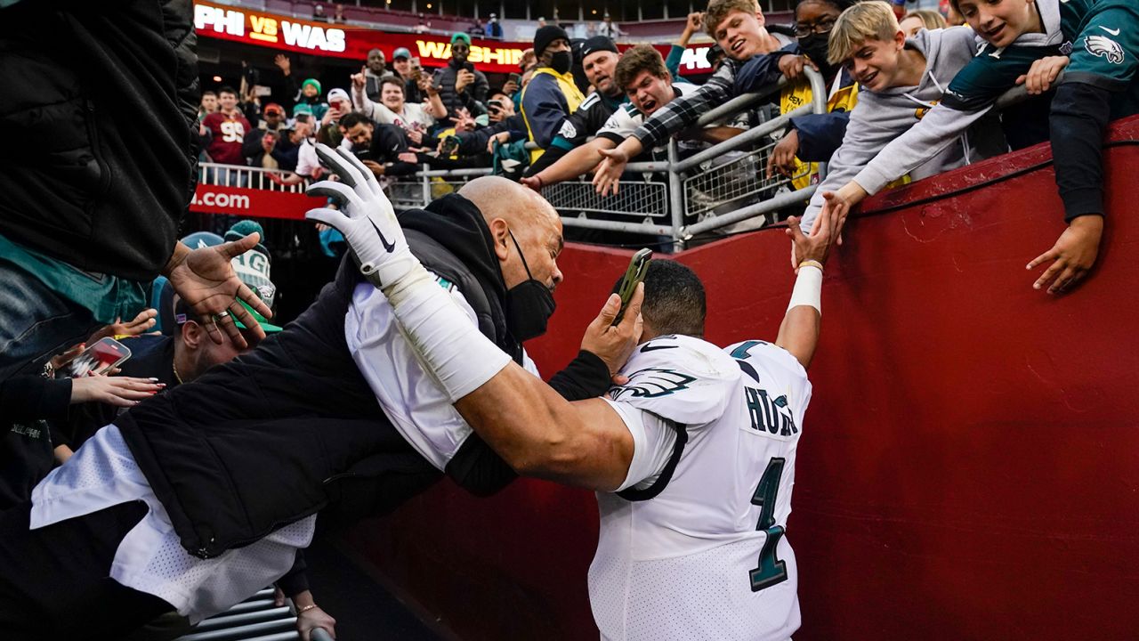 Fans fall onto Philadelphia Eagles quarterback Jalen Hurts as the railing collapsed following the end of a game on Sunday in Landover, Maryland.