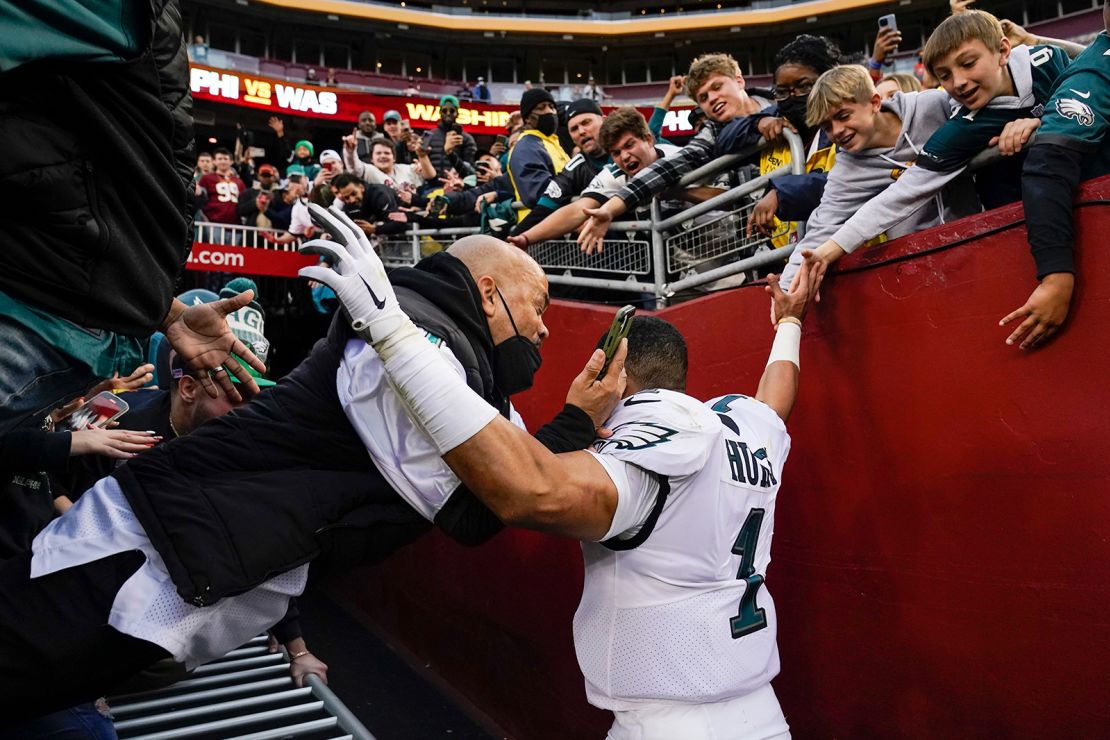 Fans fall onto Philadelphia Eagles quarterback Jalen Hurts as the railing collapsed following the end of a game on Sunday in Landover, Maryland.