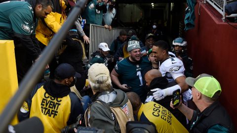 Philadelphia Eagles quarterback Jalen Hurts celebrates with fans who fell onto the ground after the railing collapsed.