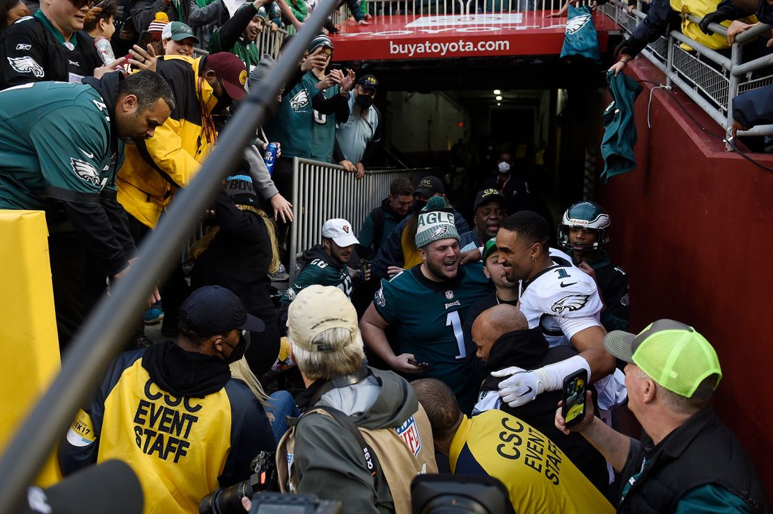 Philadelphia Eagles quarterback Jalen Hurts celebrates with fans who fell onto the ground after the railing collapsed.