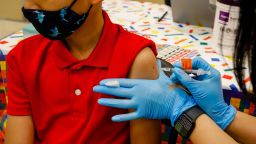 A child receives a dose of the Pfizer-BioNTech COVID-19 vaccine at an elementary school vaccination site for children ages 5 to 11-year-old in Miami, Florida, U.S., on Monday, Nov. 22, 2021.