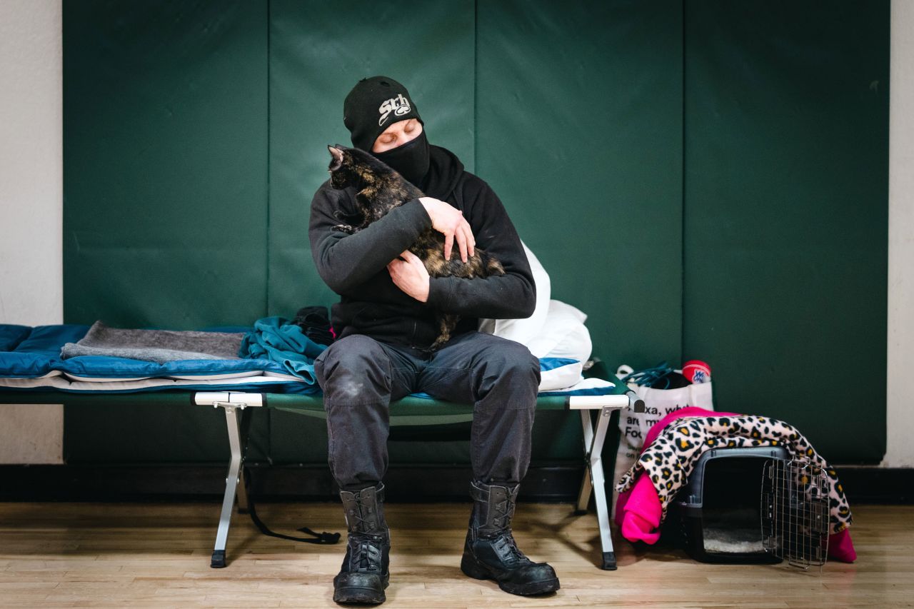 Bryan Giles holds his cat Chloe in their temporary living quarters at a Red Cross shelter in Lafayette, Colorado, on January 2.