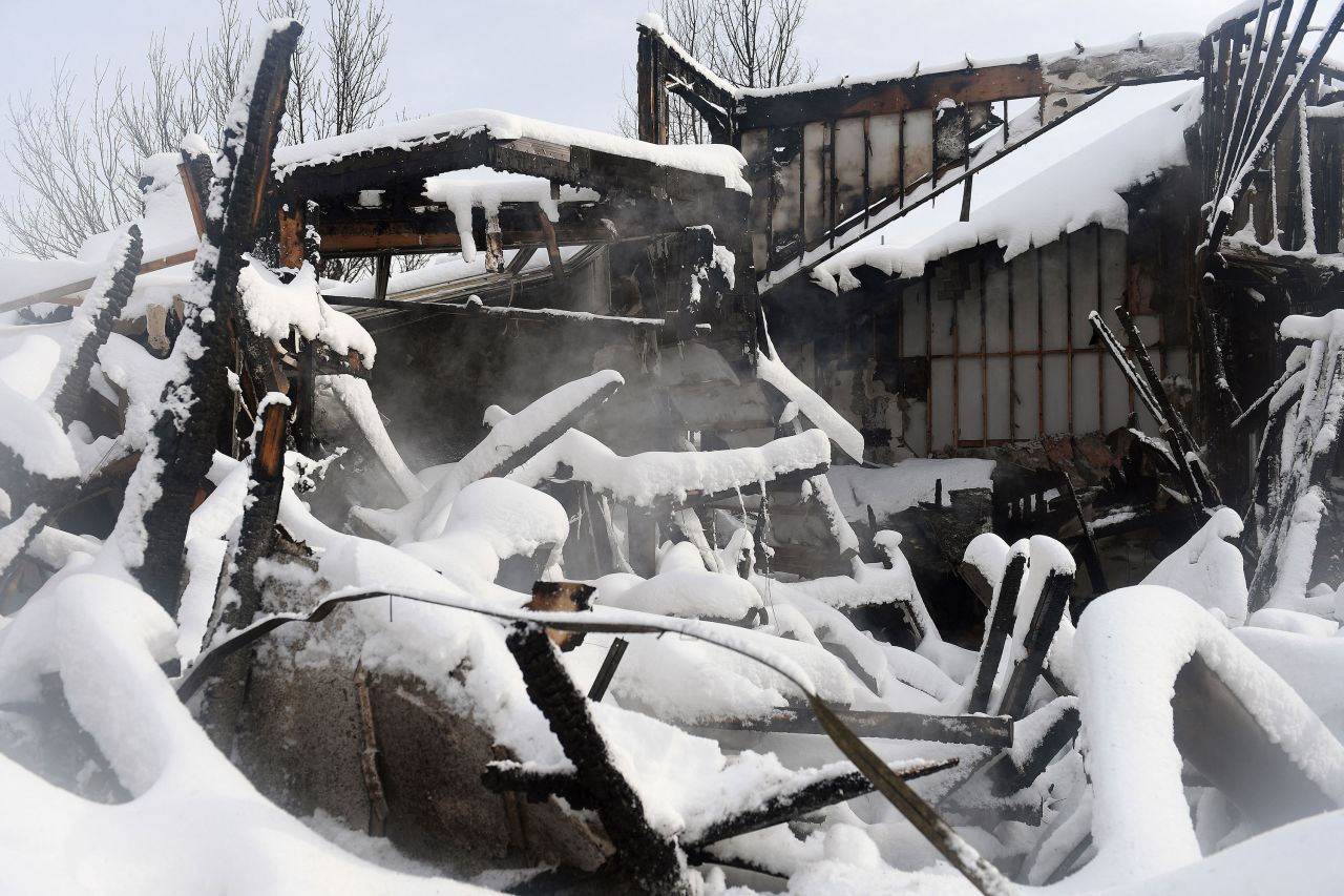 Steam rises around the snow covered remains of a home in the Rock Creek neighborhood of Superior  on January 1.