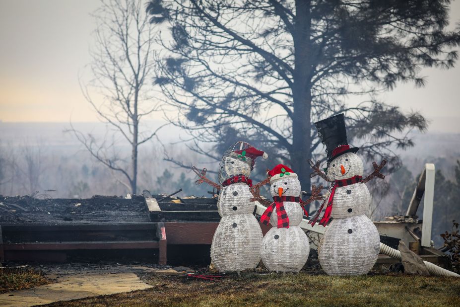 Holiday decorations stand beside the remains of a deck and home in Louisville on December 31.