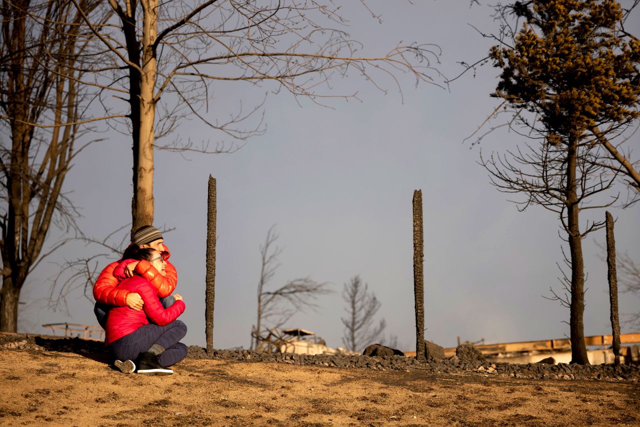 A couple grieves near the location where their house once stood in Louisville on December 31.