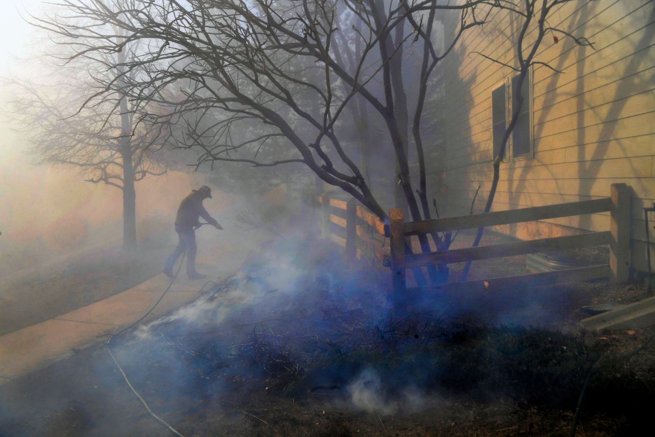 A person tries to put out fire around a house in Superior on December 30.