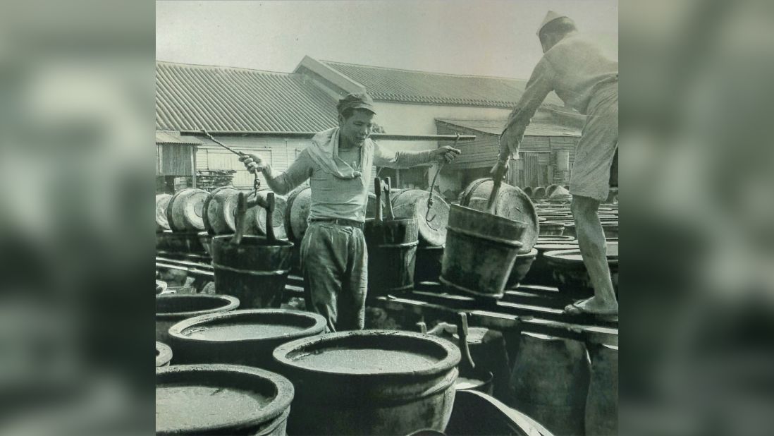 <strong>Labor intensive: </strong>Workers carry barrels of fermenting soy sauce at the original Koon Chun factory in Kowloon. 