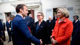 French President Emmanuel Macron, left, greets Paris' Ile de France president and candidate for the right-wing Les Republicains (LR) primary election Valerie Pecresse at the Emile Zola house in Medan, near Paris, on October 26, 2021.