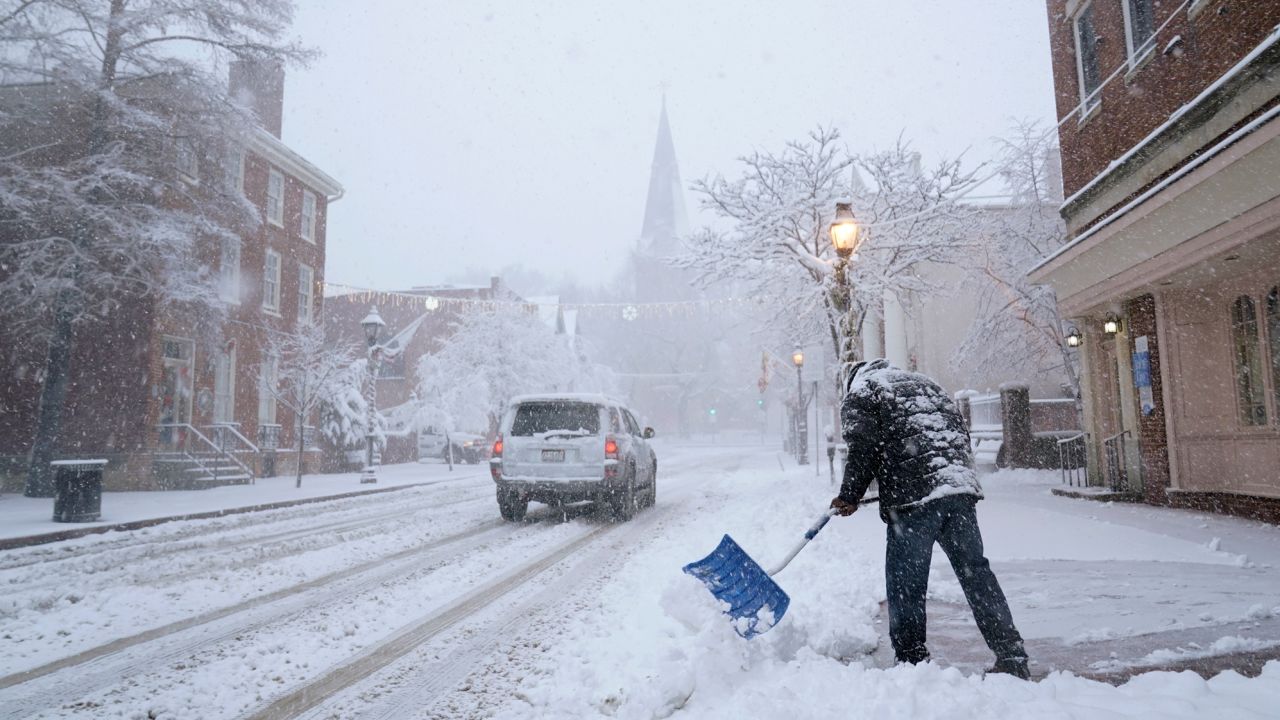 A man in Annapolis, Maryland, shovels now off a sidewalk on Monday.