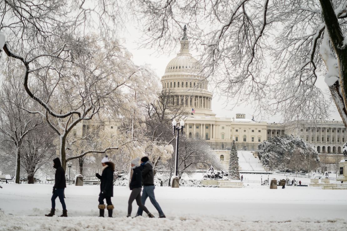 People walk along a snow covered Capitol Hill on Monday, January 3, 2022 in Washington, DC.