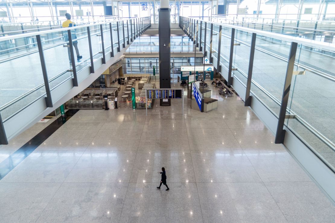 A staff member walks through the deserted arrivals hall at Hong Kong airport on November 29, 2021.