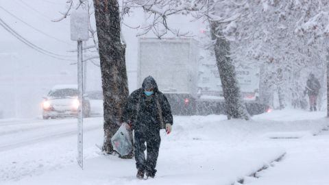 A person walks along the sidewalk in Alexandria, Virginia, as a winter snow storm hits the area Monday.