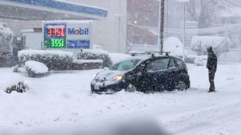 A car is stuck in the snow in Alexandria, Virginia, as a winter snow storm hits the northern part of the state Monday.