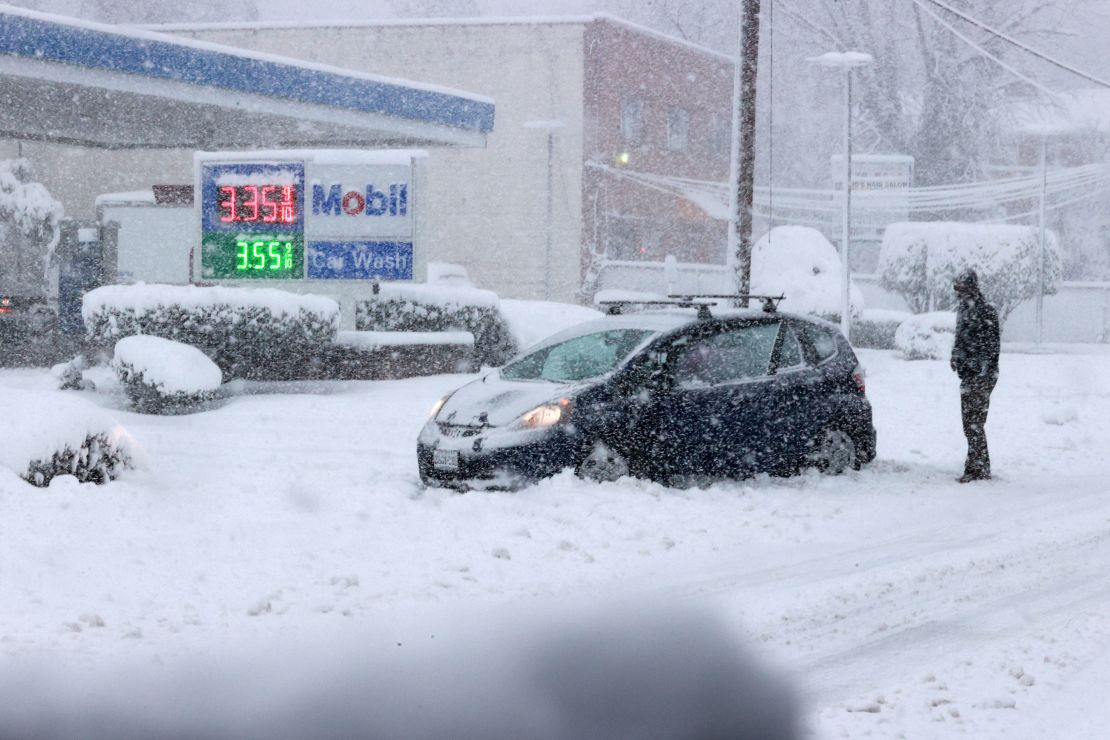A car is stuck in the snow in Alexandria, Virginia, as a winter snow storm hits the northern part of the state Monday. 