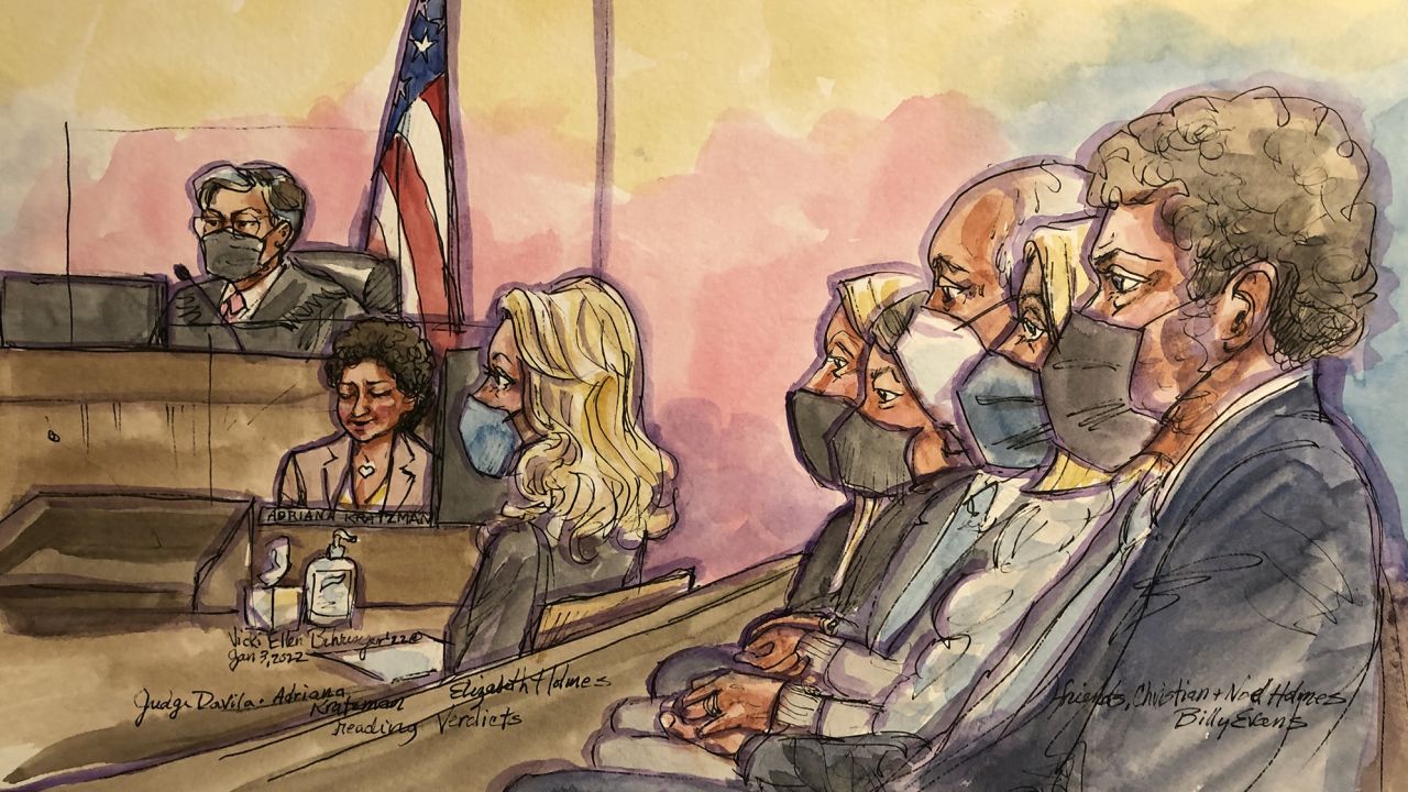 Elizabeth Holmes listens as the clerk is reading the verdict and her family is clutching each other's hands in federal court in San Jose, California, on January 3, 2022.