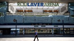 A man walks past the main entrance to Rod Laver Arena, home of the Australia Open tennis tournament in Melbourne on October 27, 2021, after the Victoria state premier stated unvaccinated players would not get special dispensation for the Australian Open Open planned for January. (Photo by William WEST / AFP) (Photo by WILLIAM WEST/AFP via Getty Images)