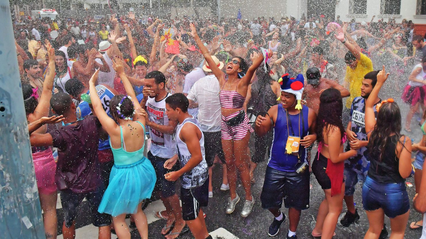 Revelers are sprayed by a water canon during a "bloco" or street party in Rio de Janeiro, Brazil on February 4, 2018.