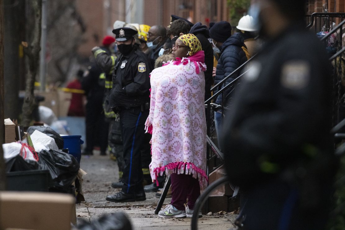 Bystanders watch as firefighters work at the scene of the fire on Wednesday morning.