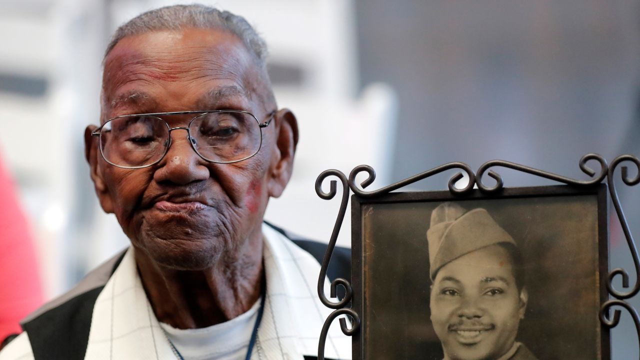 FILE - World War II veteran Lawrence Brooks holds a photo of him taken in 1943, as he celebrates his 110th birthday at the National World War II Museum in New Orleans, on Sept. 12, 2019.  Brooks, the oldest World War II veteran in the U.S. — and believed to be the oldest man in the country — died on Wednesday, Jan. 5, ,2022 at the age of 112.  (AP Photo/Gerald Herbert, File)