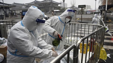 Workers disinfect packed vegetables at a residential area under quarantine in Xi'an, China, on December 25, 2021. 