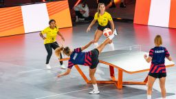USA's Carolyn Greco smashes the ball against Brazil's Natalia Guitler and Rafaella Fontes