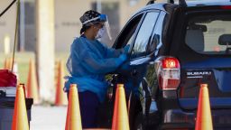 A healthcare worker administers a Covid-19 test at a drive-through testing site at Tropical Park in Miami, Florida, Thursday, Jan. 6, 2022.