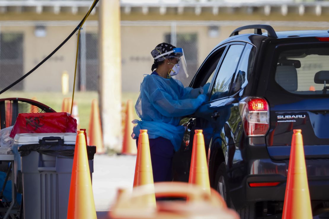 A healthcare worker administers a Covid-19 test at a drive-thru testing site at Tropical Park in Miami, on January 6.