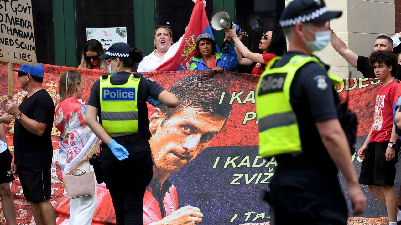 People hold placards outside the Park Hotel where 20-time grand slam champion Novak Djokovic is staying in Melbourne on January 7, 2022.