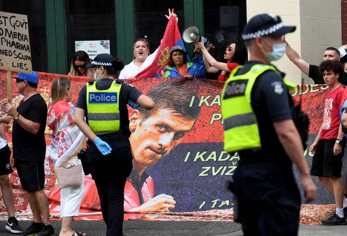 People hold placards outside the Park Hotel where 20-time grand slam champion Novak Djokovic is staying in Melbourne on January 7, 2022.
