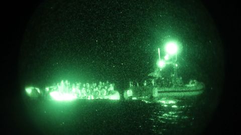 The crew of the Sentinel-class USCGC Glen Harris aboard a small boat assess an overloaded raft taking on water carrying migrants in the Atlantic Ocean prior to their subsequent rescue Jan. 5, 2021.