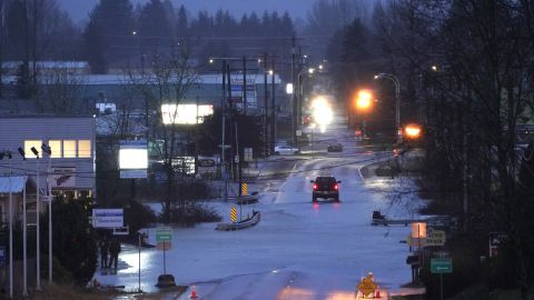 A car drives through water over the road after another storm hit the Pacific Northwest.