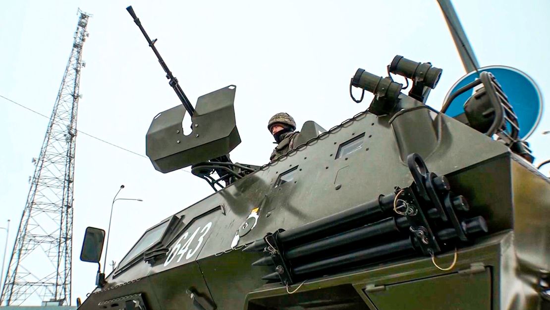 In this image taken from footage provided by Russian television, a Kazakh soldier stands atop of a military vehicle at a check point on Friday, January 7.