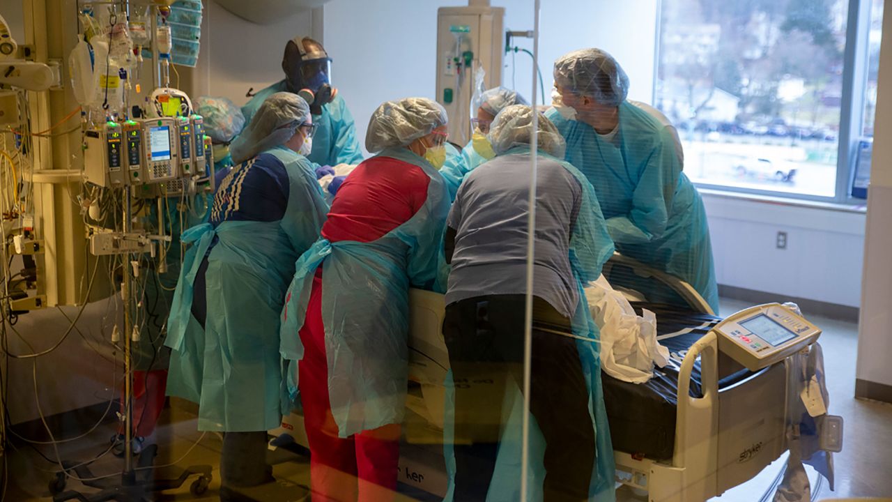 A team at the UMass Memorial Medical Center prepares to turn over a Covid-19 patient to ease the patient's breathing.