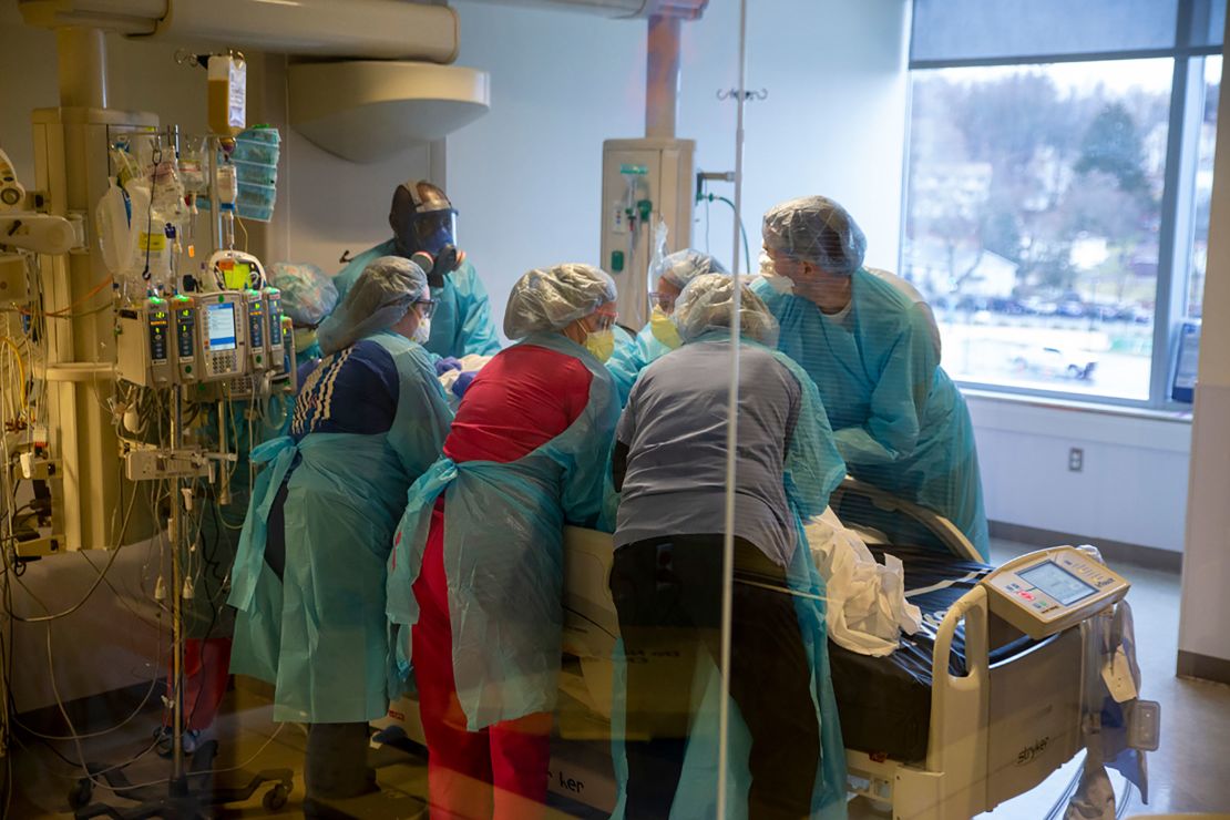 A team at the UMass Memorial Medical Center prepares to turn over a Covid-19 patient to ease the patient's breathing.