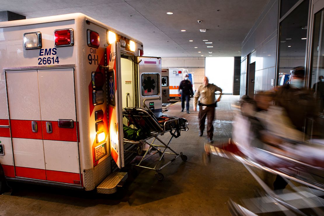 Emergency medial workers rush a patient from an ambulance into the emergency room. An empty ambulance stretcher sits nearby from the last patient who was brought in only moments earlier.