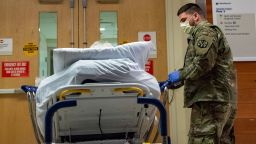A soldier transports a patient at UMass Memorial Medical Center in Worcester, Massachusetts on December 30, 2021. - The Massachusetts National Guard has activated up to 500 soldiers and airmen to help address the medical worker shortage at 55 hospitals and 12 ambulance service providers across the state.  The soldiers and airman are working in non-clinical support jobs including transporting patients, hospital security, collecting and transporting test samples, patient observation and welcoming/information roles at hospitals. (Photo by Joseph Prezioso / AFP) (Photo by JOSEPH PREZIOSO/AFP via Getty Images)