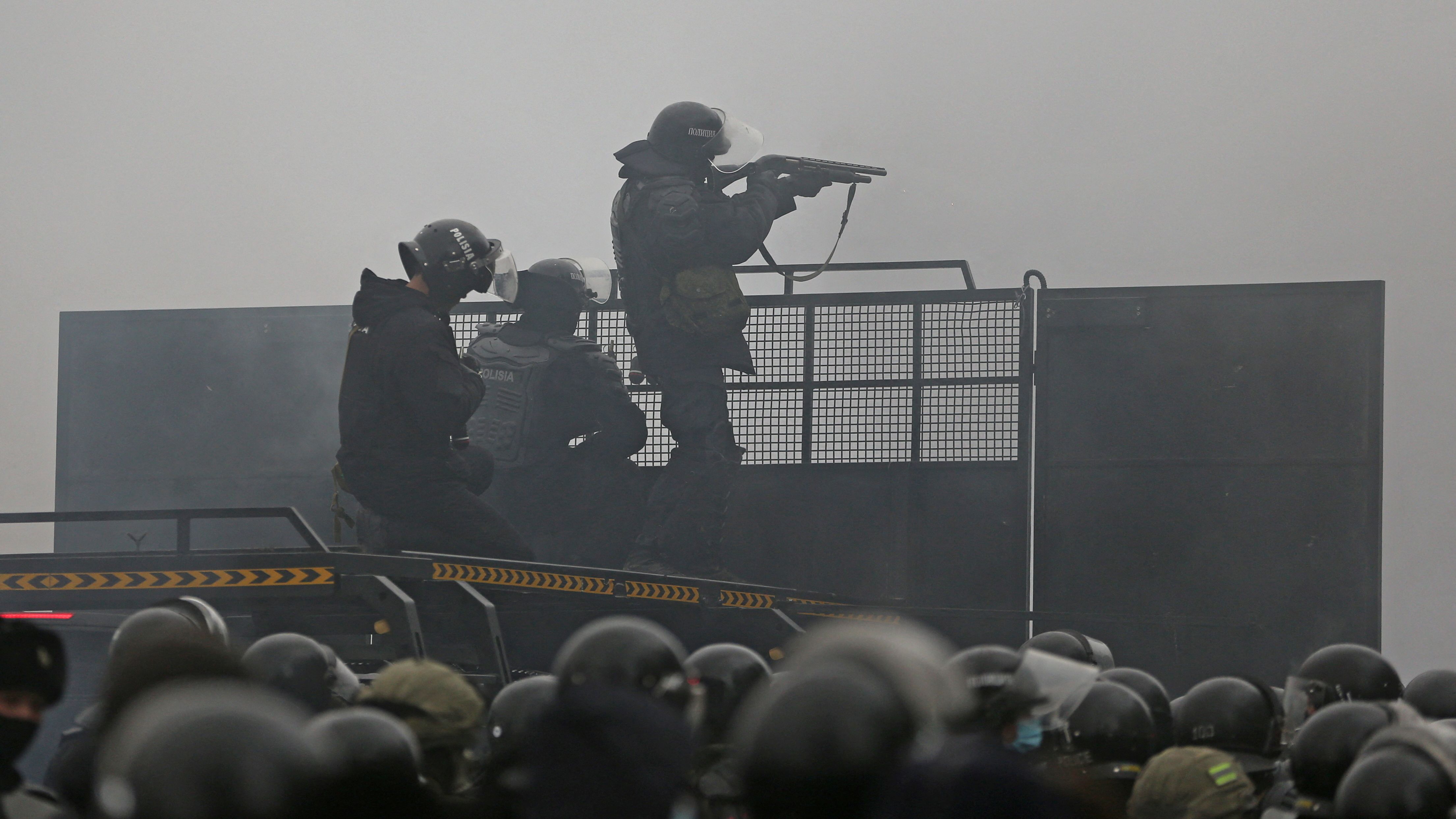 Kazakh law enforcement officers are seen on a barricade during a protest triggered by fuel price increase in Almaty on January 5.