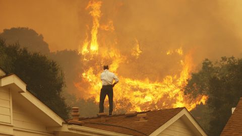 CAMARILLO, CA - MAY 3:  A man on a rooftop looks at approaching flames as the Springs fire continues to grow on May 3, 2013 near Camarillo, California. The wildfire has spread to more than 18,000 acres on day two and is 20 percent contained.  (Photo by David McNew/Getty Images)