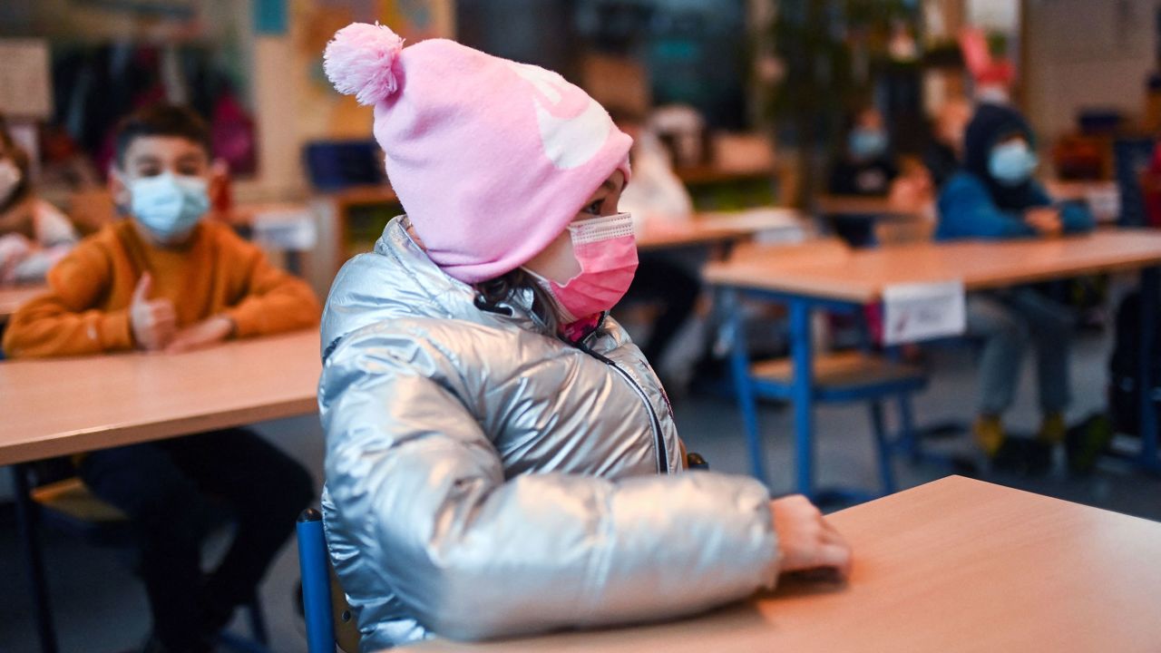 A girl wears winter clothes and a face mask in her aerated classroom at the Petri primary school in Dortmund, western Germany, in late November.