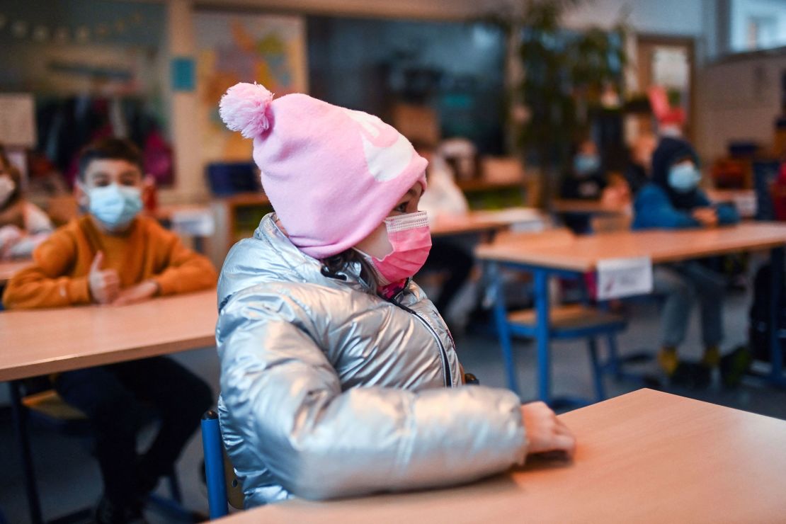 A girl wears winter clothes and a face mask in her aerated classroom at the Petri primary school in Dortmund, western Germany, in late November.