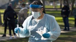 Medical assistant Leslie Powers carries swab samples collected from people to process them on-site at a COVID-19 testing site in Long Beach, Calif., Thursday, Jan. 6, 2022.