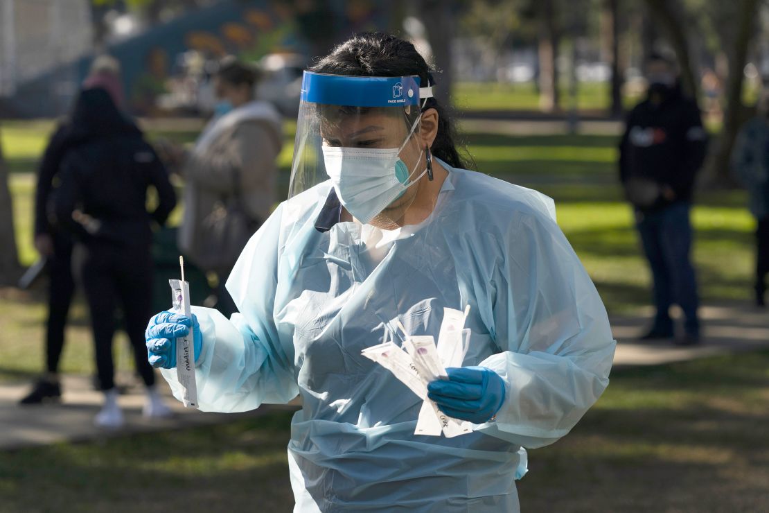 Medical assistant Leslie Powers carries swab samples collected from people to process them on-site at a Covid-19 testing site Thursday in Long Beach, California