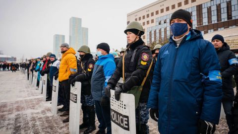 Local residents stand shoulder to shoulder with police officers at Sultan City Hall in Nur-Sultan on January 8.