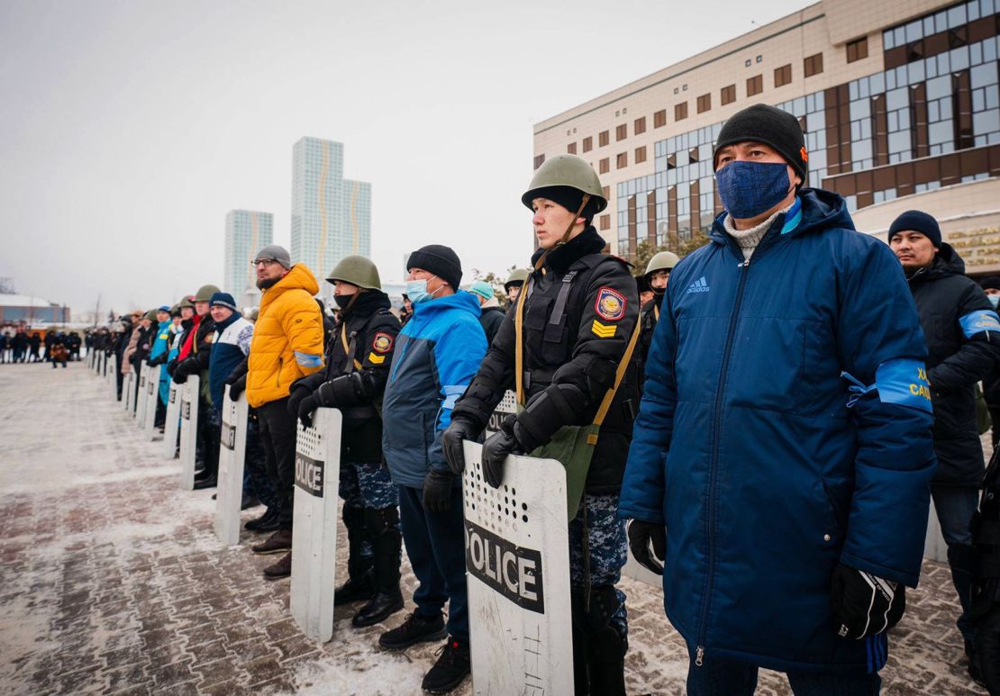 Local residents stand shoulder to shoulder with police officers at Sultan City Hall in Nur-Sultan on January 8.