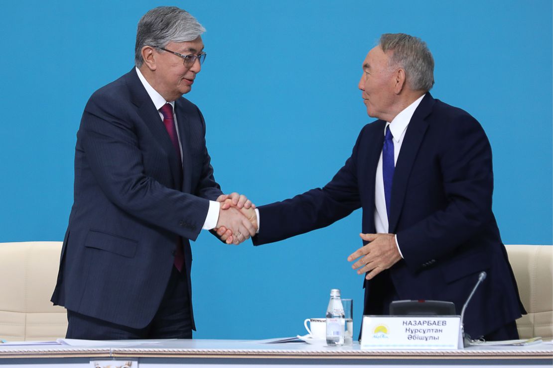 Kazakhstan's President Kassym-Jomart Tokayev (L) and former president Nursultan Nazarbaev shake hands at a party congress in 2019.