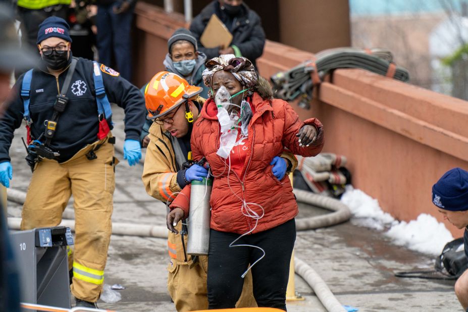 A woman is assisted by rescue personnel January 9.