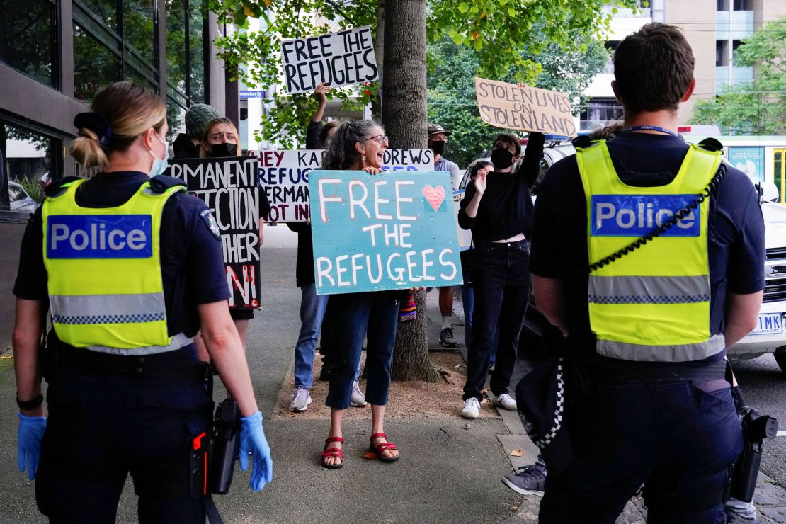 Police personnel watch pro-refugee protestors rally outside the Park Hotel, where Serbian tennis player Novak Djokovic is believed to be held, in Melbourne, Australia, January 10.